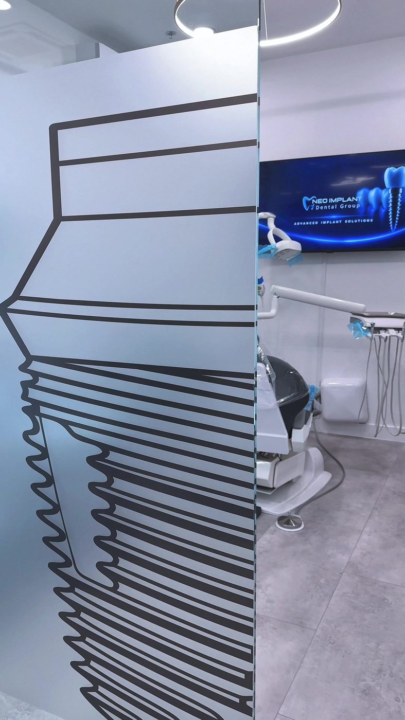 Neo Implant Dental Group treatment room in San Bernardino — modern dental chair, implant graphic partition, branded display