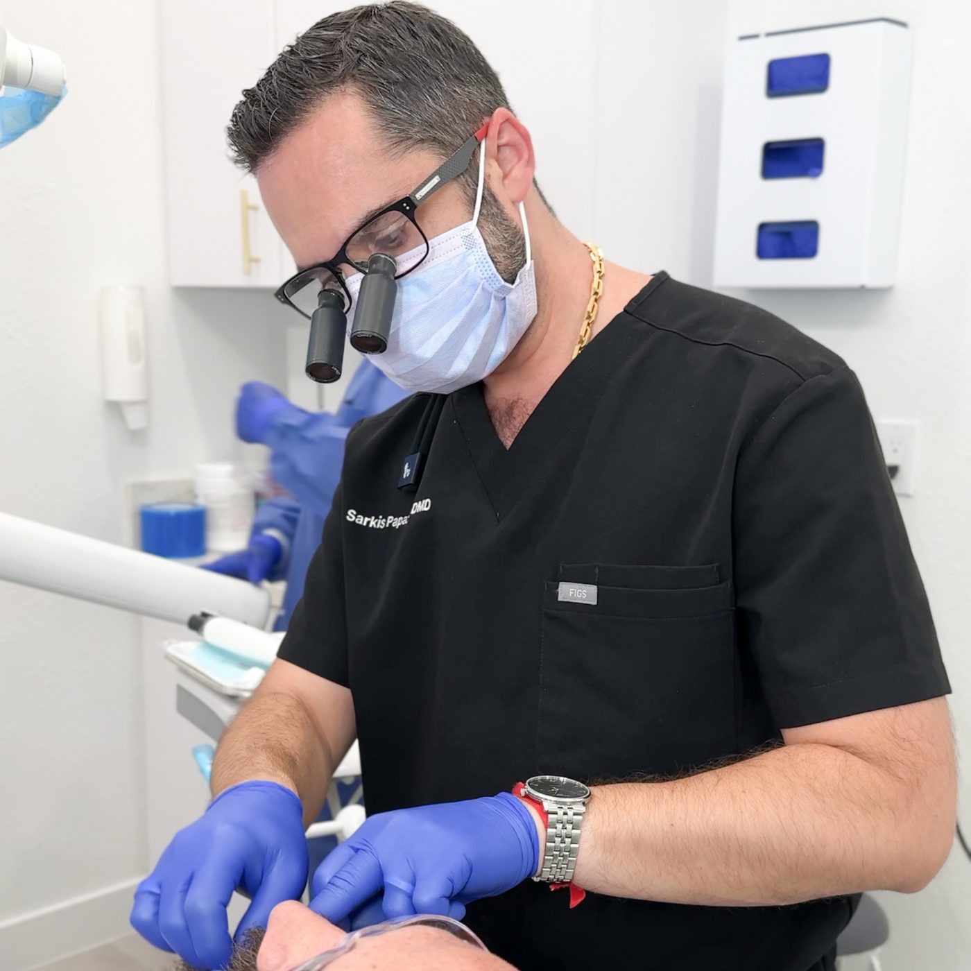 Dr. Sarkis Papazian, DMD — treating a patient with surgical loupes at Neo Implant Dental Group, San Bernardino